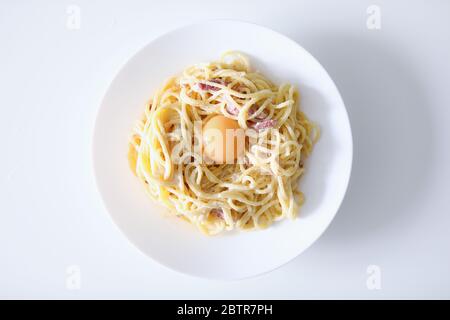 Pâtes Carbonara avec jaune d'œuf et bacon de fond fermé Banque D'Images