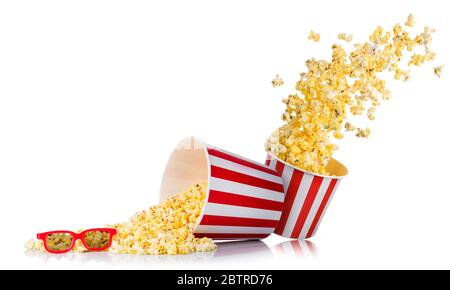 Ensemble de pop-corn volant provenant du seau en papier et de pop-corn dispersé isolé sur du blanc Banque D'Images