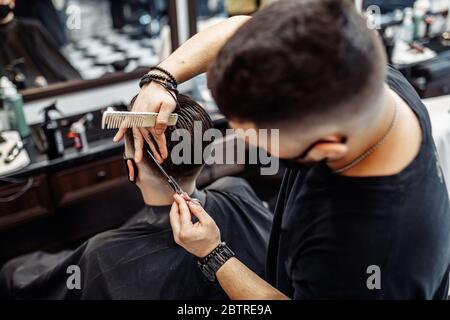 Barber fait une coupe de cheveux et coiffage dans un salon de beauté de barbershop. Banque D'Images