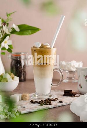 Dalgon de café froid dans un grand verre sur un fond en bois beige. Mousse fouettée avec un batteur à sucre, café instantané et eau dans le lait froid avec moi Banque D'Images