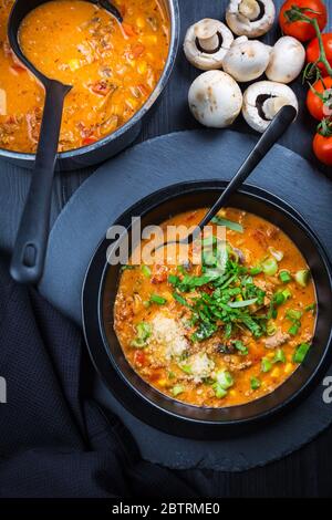 Soupe à la pizza - utilisation de restes pour la cuisson. Soupe maison fraîche avec tomate, champagnon, bœuf, maïs et mozzarella Banque D'Images