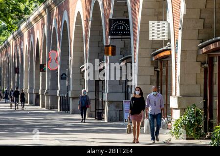 Paris, France - 19 mai 2020 : jeune homme et femme marchant dans la rue de Paris près de 'la coulée verte' avec un masque chirurgical pour se protéger Banque D'Images