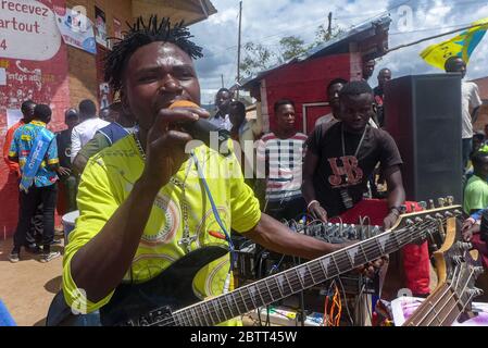 Ringo Ramazani, le chef d'un groupe de musique connu sous le nom de jeu du ciel, chante et joue de la guitare lors d'un événement mis en place en l'honneur d'une visite de Carly Nzanzu Kasivita, le gouverneur de la province du Nord-Kivu, à Kirumba, en République démocratique du Congo. Les politiciens, les membres des partis politiques et les gens de tous les milieux se sont réunis pour l'occasion. (Merveille Kavira Luneghe, GPJ République démocratique du Congo) Banque D'Images