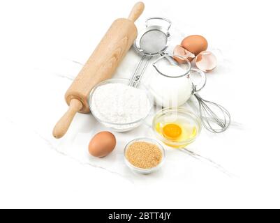 Ingrédients alimentaires oeufs, farine, sucre, lait. Outils de cuisine. Préparation de la pâte Banque D'Images