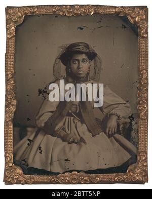 Ambrotype d'une jeune femme non identifiée. Cette photographie en noir et blanc est un portrait de trois quarts de longueur d'une jeune femme non identifiée assise avec son coude gauche reposant sur une table. Banque D'Images