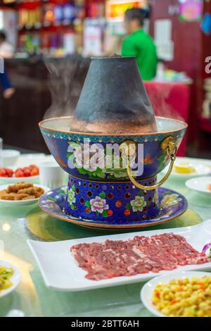 Pékin / Chine - 31 décembre 2015 : traditionnel Beijing style chinois charbon-chauffe pot en laiton placé au centre de la table à manger dans un restaurant Banque D'Images