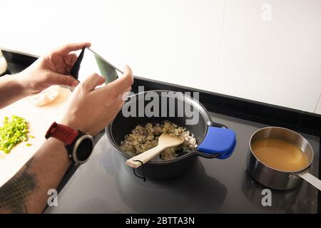 détail des mains prendre une photo avec le téléphone tout en cuisant une recette de repas saine, concept de technologie et de nourriture saine Banque D'Images