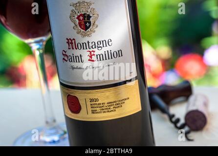 BOUTEILLE DE SAINT EMILION et verre de vin de la poste daté du 2020° de montagne Saint-Emilion en plein air dégustation de vins sur la table de jardin française Banque D'Images