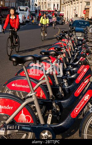 Vélos transport de Londres TFL avec Santander ligne de location de vélos rouges vélos vélos à Southwark Street avec Londres navetteurs sur des vélos portant des casques de sécurité vélo passé, transport pour Londres Southwark Londres UK Banque D'Images