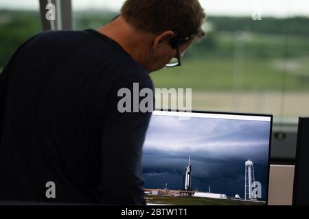 Cape Canaveral, Floride, États-Unis. 27 mai 2020. Hans Koenigsmann, vice-président de la fiabilité de construction et de vol chez SpaceX, Regarde un moniteur montrant une alimentation en direct d'une fusée SpaceX Falcon 9 transportant le vaisseau spatial Crew Dragon de la société sur le plateau de lancement pendant le compte à rebours pour une tentative de lancement de la mission SpaceX Demo-2 de la NASA avec les astronautes de la NASA Robert Behnken et Douglas Hurley à bord, le 27 mai 2020, Dans la salle de tir quatre du Launch Control Center du Kennedy Space Center de la NASA en Floride. Crédit : UPI/Alay Live News Banque D'Images