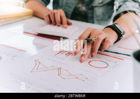 Gros plan de la main comptable tenant le stylo travaillant sur la calculatrice Banque D'Images