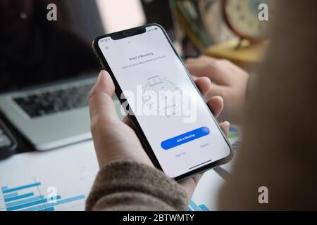 CHIANG MAI, THAÏLANDE - APR 11, 2020 : UN employé travaillant à domicile télécharge la plate-forme sociale de l'application Zoom, Banque D'Images