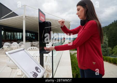 Les clients du restaurant se lavant les mains à l'aide d'un désinfectant automatique à base de gel. Prévention des coronavirus dans un restaurant de caffee pendant la corona viru Banque D'Images