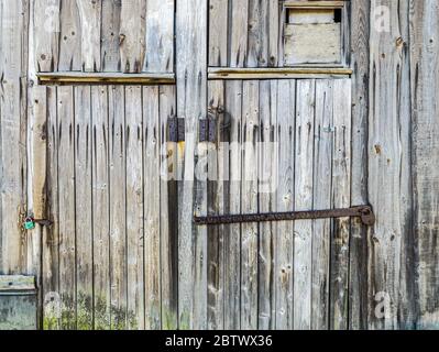 vue détaillée d'un ancien mur de grange en bois et de portes fermées avec cadenas rouillés Banque D'Images