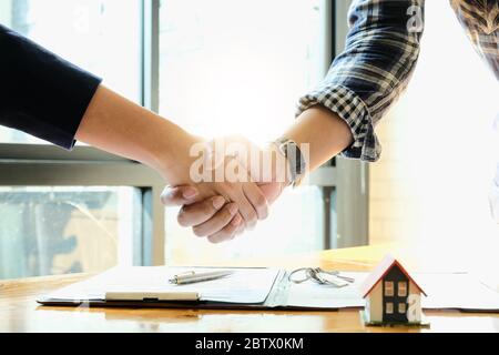 Agent immobilier et clients qui se sont réunis pour célébrer le contrat fini Banque D'Images