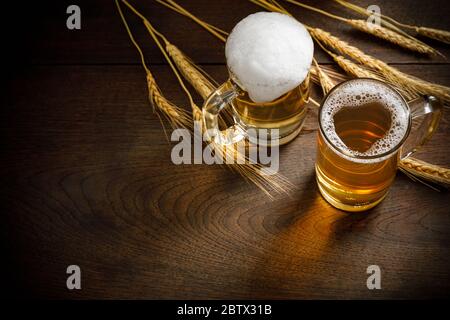 Verres de bière légère avec blé sur la table en bois, copier l'espace pour votre texte Banque D'Images