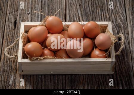 Faire revenir les œufs dans une boîte en bois sur une table en bois, œuf de poulet Banque D'Images