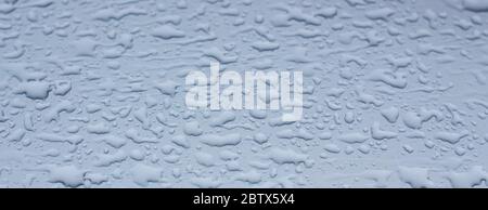 Gouttes de pluie sur métal gris. L'eau sur la voiture après la pluie. Banque D'Images