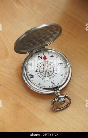 Gros plan d'une vieille boussole ancienne avec un fond de table en bois Banque D'Images
