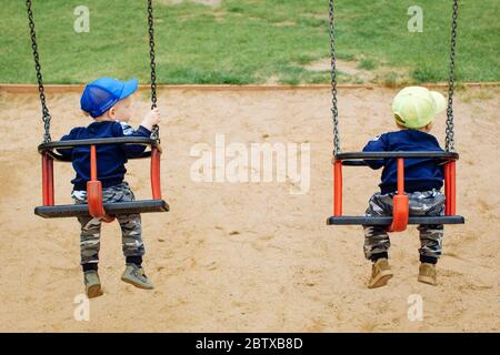 2 frères jumeaux se rassemblent sur une balançoire, 1-2 ans Banque D'Images
