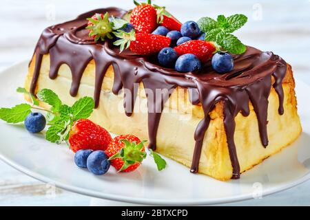 Syrnyk Lviv traditionnel ukrainien ou cheesecake Lviv de fromage cottage, raisins secs avec glaçage au chocolat servis avec des bleuets frais, des fraises, de la menthe Banque D'Images