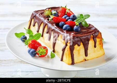 Dessert ukrainien : cheesecake lviv de fromage cottage, beurre, raisins secs nappés de chocolat servi avec des baies fraîches, des bleuets, des fraises, de la menthe Banque D'Images