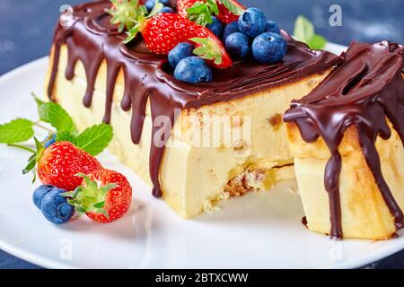 Cheesecake ukrainien de l'Ouest cheesecake lviv de fromage cottage, beurre, raisins secs nappés de chocolat servi avec des baies fraîches, bleuets, fraises Banque D'Images
