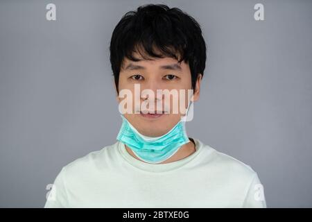 l'homme enlève un masque médical (masque chirurgical) et sourit Banque D'Images