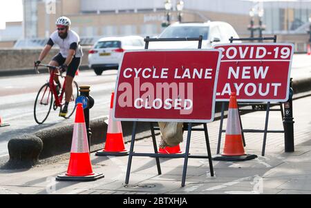 Londres, Royaume-Uni. 28 mai 2020 London Borough of Kingston upon Thames Council ajoute une signalisation temporaire à un point de pincement sur le pont Kingston. Ils ont fait de la piste cyclable une route piétonne pour aider à prendre des distances sociales. Andrew Fosker / Alamy Live News Banque D'Images