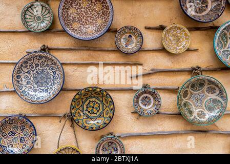 plaques en céramique traditionnelles à motifs, exposées sur un mur. Le mur est de couleur ocre. Les plaques sont en portugais ou en turc Banque D'Images