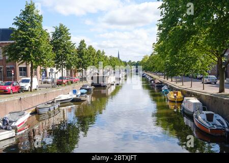 La Haye, pays-Bas - Mai 15 2020 : Canal avec réflexion de bateaux et d'arbres, rue remplie de voitures et de maisons à la Haye, pays-Bas Banque D'Images