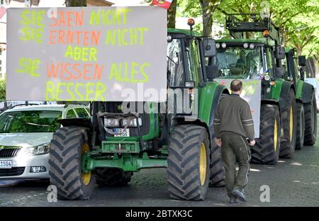 28 mai 2020, Schleswig-Holstein, Neumünster: Les agriculteurs protestant se tiennent avec des tracteurs devant le bureau régional de l'association pour la conservation de la nature NABU. Les agriculteurs de l'initiative « Wir bitten zu Tisch » (nous demandons la table) sont venus avec leurs tracteurs au bureau pour faire une démonstration contre les réglementations environnementales. Photo: Carsten Rehder/dpa Banque D'Images