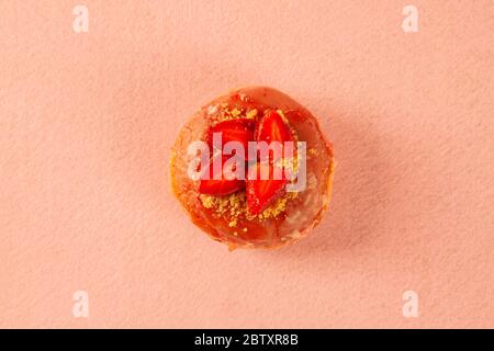 Un seul beignet de gâteau court à la fraise sur fond rose Banque D'Images