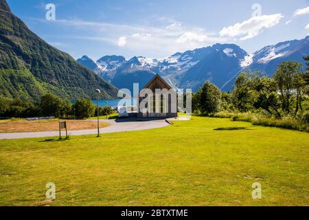 Scène pittoresque du village d'Urke et du fjord d'Hjorundfjorden, Norvège. Le ciel Drammatic et les montagnes sombres. Photographie de paysage Banque D'Images