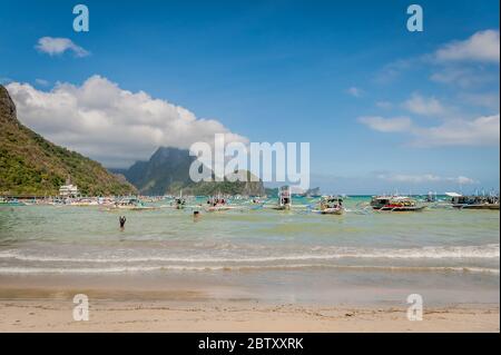 Scène matinale à la plage d'El Nido, El Nido, Palawan, Philippines tandis que les bateaux de jour se préparent à emmener les touristes vers les îles et les plages. Banque D'Images
