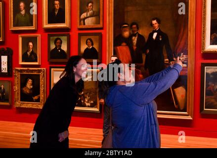 (200528) -- WELLINGTON, le 28 mai 2020 (Xinhua) -- UN visiteur prend un selfie avec le Premier ministre néo-zélandais Jacinda Ardern (L) au musée national 'te Papa' de Wellington, Nouvelle-Zélande, le 28 mai 2020. Le musée national de Nouvelle-Zélande « te Papa » a rouvert jeudi après la fermeture pendant plus de deux mois afin de protéger le public contre les risques liés à la COVID-19. Le musée national a fermé ses portes le 20 mars. La fermeture de 68 jours est la plus longue de l'histoire du musée. Jeudi, à te Papa, le Premier ministre Jacinda Ardern a annoncé que le musée recevra 18 millions de dollars supplémentaires en Nouvelle-Zélande Banque D'Images