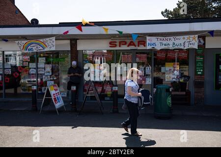 Wollaston High Street, où l'artiste Luke Perry a accroché des banderoles, avec des messages de soutien aux voisins et aux travailleurs clés, pour créer un couloir de couleur de 500 mètres à travers le village des West Midlands. M. Perry a demandé aux résidents et aux commerçants locaux de soumettre des dessins et des messages qu'il a ensuite peints et cousus à la main sur des banderoles avec l'aide de bénévoles. Banque D'Images