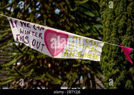 La rue Duncombe à Wollaston, où l'artiste Luke Perry a accroché des messages de soutien aux voisins et aux travailleurs clés, pour créer un couloir de couleur de 500 mètres à travers le village des West Midlands. M. Perry a demandé aux résidents et aux commerçants locaux de soumettre des dessins et des messages qu'il a ensuite peints et cousus à la main sur des banderoles avec l'aide de bénévoles. Banque D'Images