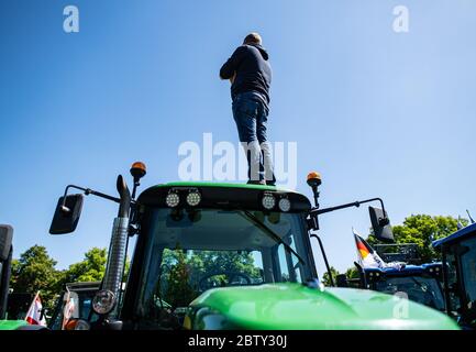 28 mai 2020, Rhénanie-du-Nord-Westphalie, Münster : un agriculteur est sur son tracteur. Les agriculteurs qui ont environ 1200 tracteurs participent à cette action de protestation. Avec des convois de tracteur dans de nombreuses villes, les agriculteurs veulent céder à leur protestation contre la politique agricole. Le ressentiment des agriculteurs est principalement dirigé contre le ministre fédéral de l'Environnement, M. Schulze. Credit: dpa Picture Alliance/Alay Live News Banque D'Images