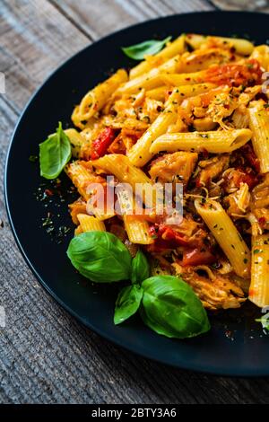 Pâtes avec sauce tomate et légumes sur table en bois Banque D'Images