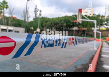 Terrain de basket-ball fermé au parc. Bandes de restriction de la police locale autour du champ vide en raison de la pandémie du coronavirus COVID-19. Banque D'Images