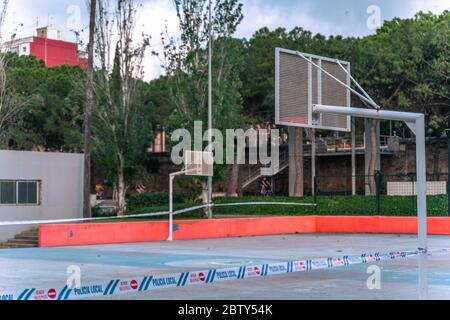 Terrain de basket-ball fermé au parc. Bandes de restriction de la police locale autour du champ vide en raison de la pandémie du coronavirus COVID-19. Banque D'Images