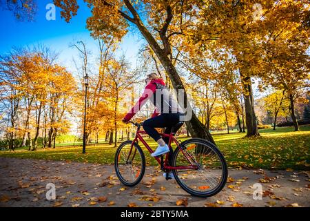 Le vélo urbain - woman riding bike in city park Banque D'Images