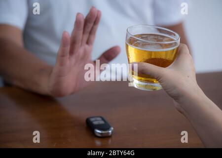 Ne buvez pas de voiture et l'homme refusant la bière d'alcool montrant la clé de voiture comme geste de ne pas boire et conduire Banque D'Images