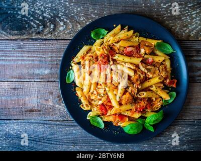 Pâtes avec sauce tomate et légumes sur table en bois Banque D'Images