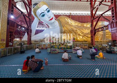 Pèlerins priant devant le Bouddha couché au Temple du Bouddha de Chaukhtatgyi, Yangon (Rangoon), Myanmar (Birmanie), Asie Banque D'Images