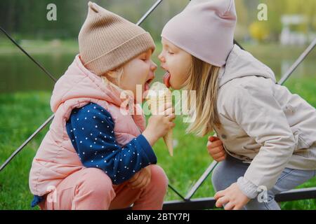 petites filles de 3 ans qui mangent de la glace ensemble dans le parc Banque D'Images