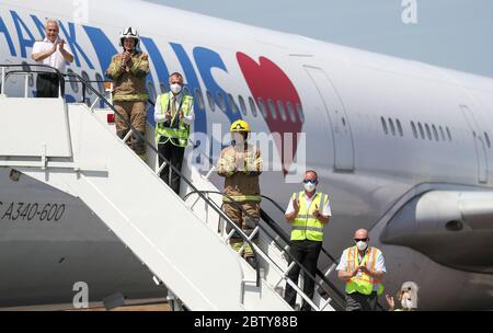 L'équipage d'un vol du groupe d'aviation européen, sur le point de partir pour la Chine pour récupérer des EPI, se tient devant son avion à l'aéroport international de Bournemouth, aux côtés du personnel et des pompiers de l'aéroport de Bournemouth, Alors qu'ils se joignent aux applaudissements pour saluer les héros locaux lors du Clap national de jeudi pour que les soignants reconnaissent et soutiennent les travailleurs du NHS et les soignants qui luttent contre la pandémie du coronavirus. Banque D'Images