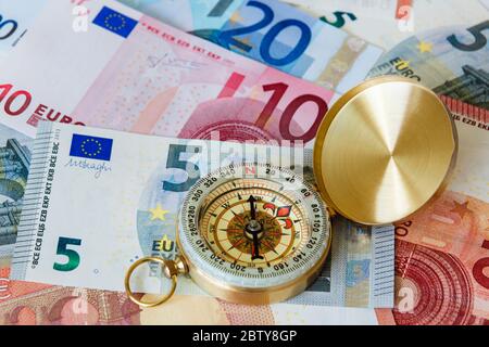L'euro est accompagné d'une boussole en cuivre pour illustrer l'avenir de l'économie de la zone euro. Concept de changement de direction. Europe Banque D'Images