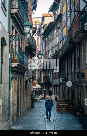 Un homme solitaire marchant le long d'une rue arrière à Porto, Portugal, Europe Banque D'Images